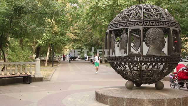 Люди гуляют по парку около памятника Пушкину. Парк, сквер, дорожки, деревья, пешеходы, люди,...