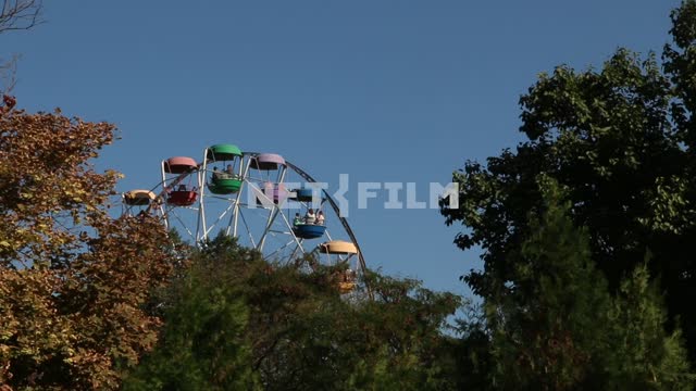 The Ferris wheel in the Park. The Ferris wheel, attraction, cabins, trees, sky, autumn, leaves, Park