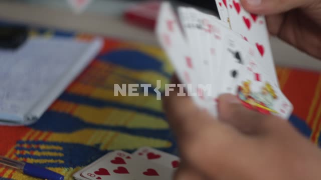 People are playing cards. cards, whist, hand, closeup, notebook, notes, pen
