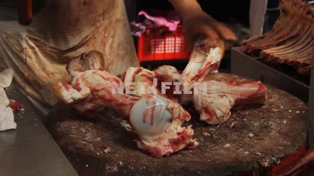 Butcher cut up the beef leg. butcher, meat, knife, cow, market
