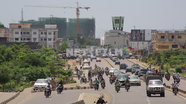 Highway in the African city, people travel by cars and motorcycles Africa, highway, motorcycles,...