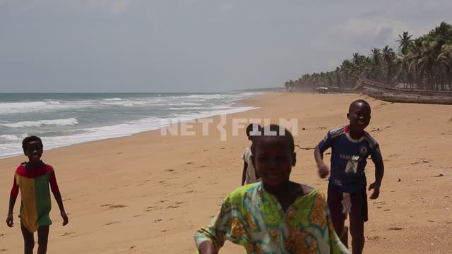 Африканские дети бегут по песчаному берегу океана, выделывая трюки Дети, Африка, берег океана,...