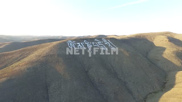 Аэросъемка, вид сверху на огромную надпись на санскрите на горе, марсианский пейзаж. Тува, горы...
