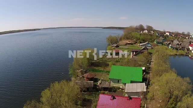 Aerial photography over water, the transition to shore with small houses, the town Sebezh, water...