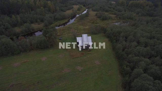 Aerial photo, survey copter, a beautiful house in a forest glade, riverside, river receding into...