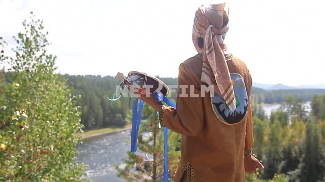 Shaman with a tambourine preparing for the ceremony on the high Bank of the mountain river Shaman...