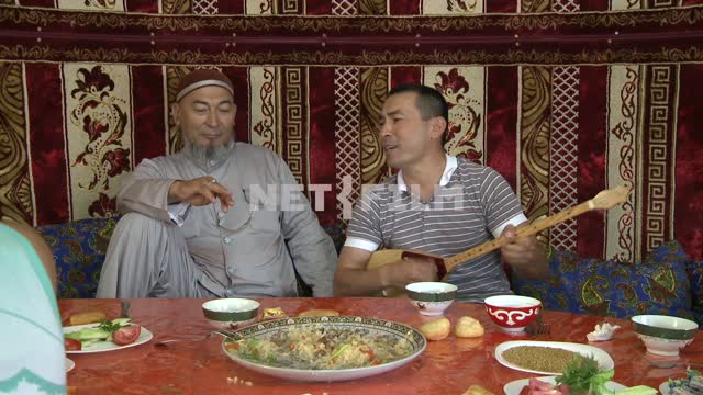 Многочисленная казахская семья сидит за столом в юрте,
Национальный колорит,
Национальная казахская...