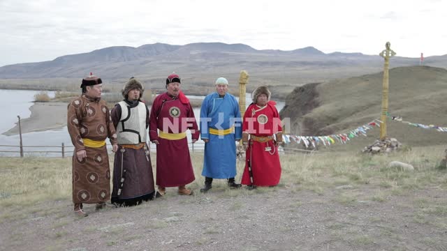 Men in traditional Tuvan garb on a background of mountains. throat singing Men in traditional Tuvan...