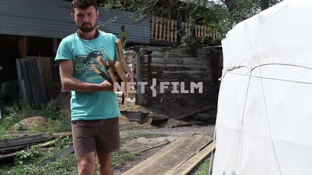 The bearded guy collects firewood and carries them into the tent-tent The bearded guy collects...