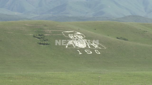 A giant portrait of an old man on the hillside, a modern geoglyph, mountain, sky, nature, clouds A...