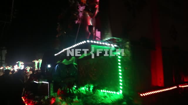 at night the street of Indian town on the car driven flowered throne, where sitting in festive...