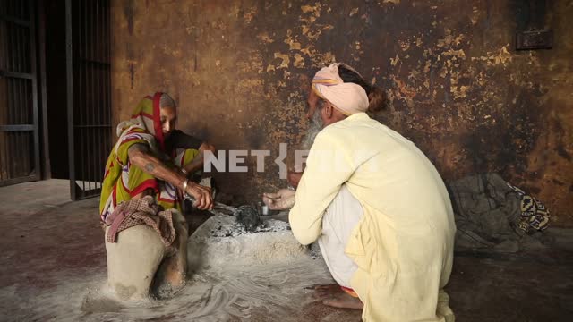 в индийском крематории индийская женщина разговаривает с индийским стариком и в потухшем костре...