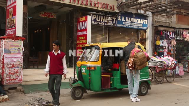 Indian calving out a male Caucasian with a backpack and sits down in an Indian taxi Indian hotel,...
