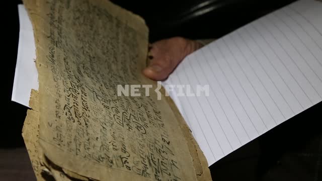 closeup of hand holding an old yellowed leaves with Indian text Indian scripts, archive, yellowed...