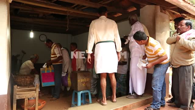 индийский мужчины стоят в очереди к индийскому знахарю, который раздает целебную сушеную смесь...
