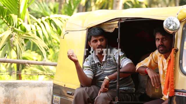 Indian men sit in the car, one standing by the car, talking car, palm trees, Indian men, exoticism,...