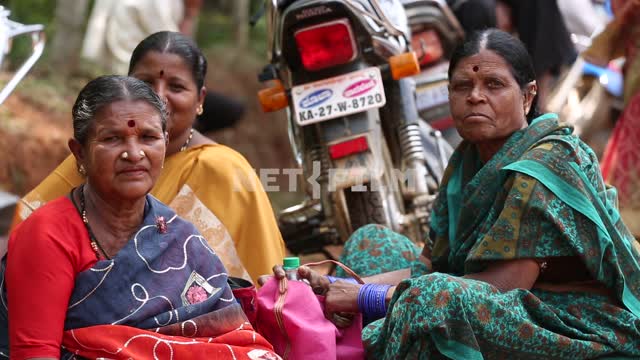 три индийских женщин смотрят в камеру на фоне мотоцикла женщины,национальная одежда, индия,...