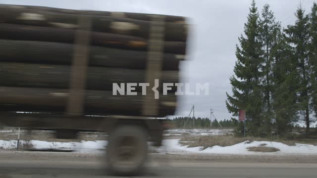 Два лесовоза проезжаеют по дороге один за другим. Зима, Россия, вырубка, лесовоз, лесовозы, бревна,...