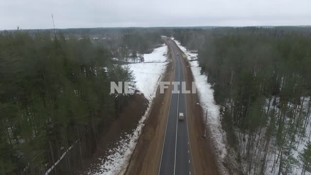 Top view car goes around the track in a snowy forest, crosses the bridge.
Car, winter, drone,...