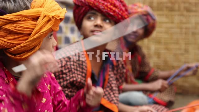 Child actors in exotic headdresses performing on the street in the slums Children-actors,...