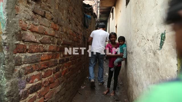 Люди идут по узкой улочке в индийских трущобах Люди,бедняки, узкая улочка, трущобы
