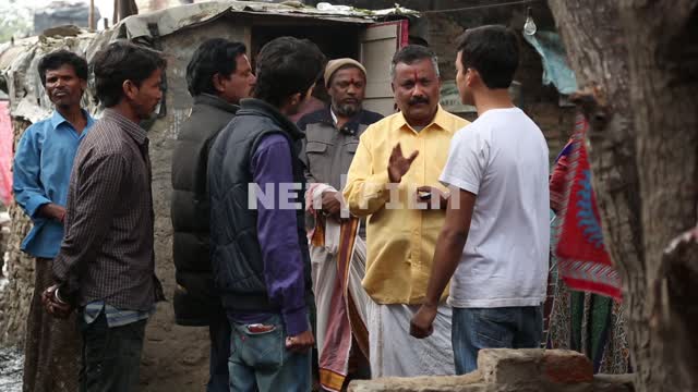 Мужчина - индус в желтой одежде стоит окруженные молодыми людьми и что-то им рассказывает Индусы,...