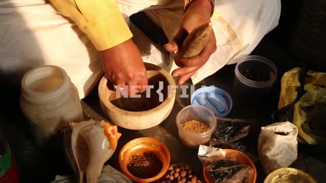 Hands of the healer rubbed the potion in the mortar around the jars with herbs Healing, preparation...