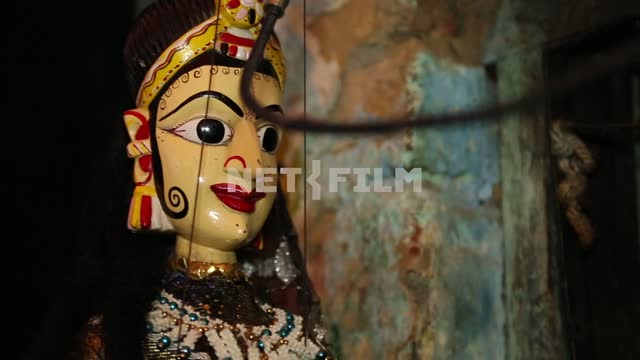 Кукла - индианка качается на нитках на фоне живописной ободранной стены Кукла - индианка, экзотика,...
