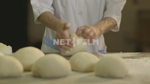 Close-up. Baker vymeshivaem dough.
Bakery, counter, dough, shapes, cakes, bread, baguette, loaf,...