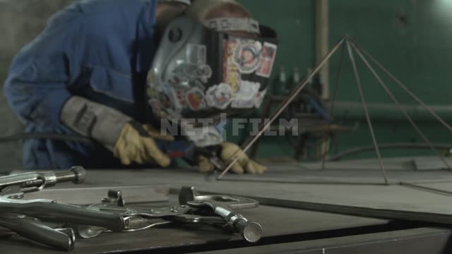 The welder assembles metal lamp.
Master, welder, welding, grinder, helmet, spark, sticker, rod,...