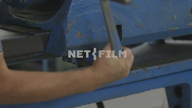 Worker inserts the lever-brace in the slot machine.
Factory, aircraft construction, curve, detail,...
