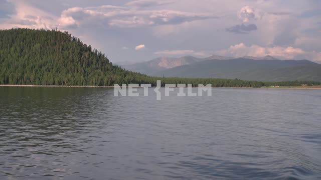View from the boat on the shore of lake Baikal, the taiga and the Barguzin mountain range Russia,...