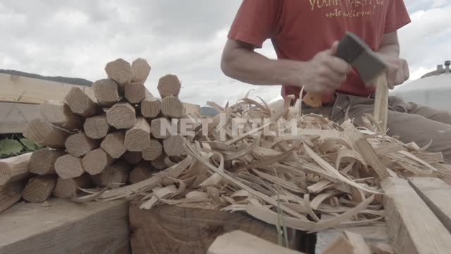Close-up.
A man hew a stake with an axe.
Man, hands, tools, stakes, pegs, wooden stakes, shavings,...