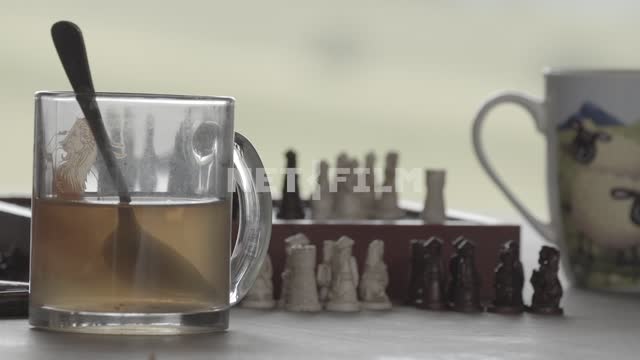 Крупный план. Чашки с чаем, шахматная доска, фигуры. Шахматы, коробка, фигуры, чашка, чашки, чай,...