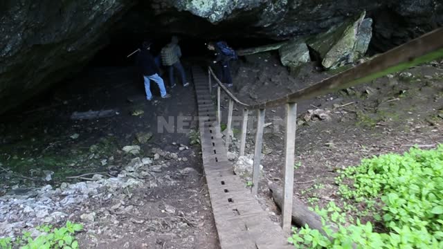 Askinskaya cave, descending a wooden staircase, shooting from the movement, people at the entrance...