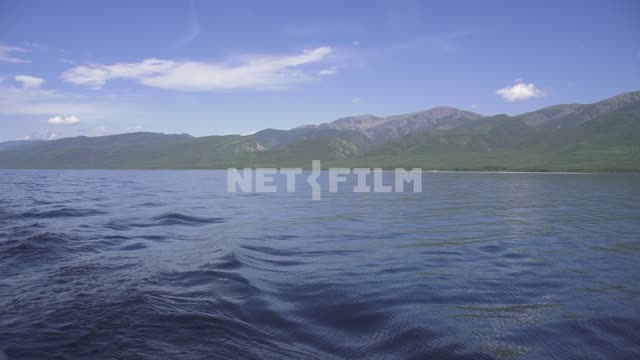 View from the boat on the shore of lake Baikal, mountains covered with forests Russia, Siberia,...