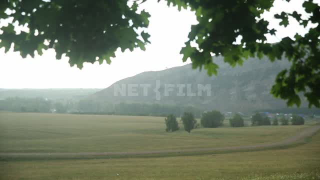 Nature of the Urals, view of the field from under the maple tree Gafuri district, mountains, hills,...
