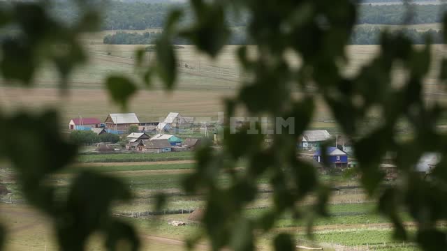 Nature of the Urals, view of the village through the foliage, shooting with a change of focus...