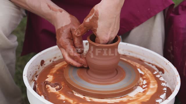A man works on a potter's wheel, making a jug Ural, Salavatsky district, holiday, fair, souvenirs,...