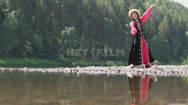 A girl in a national costume dances on the river bank Ural, Salavatsky district, girl, national...