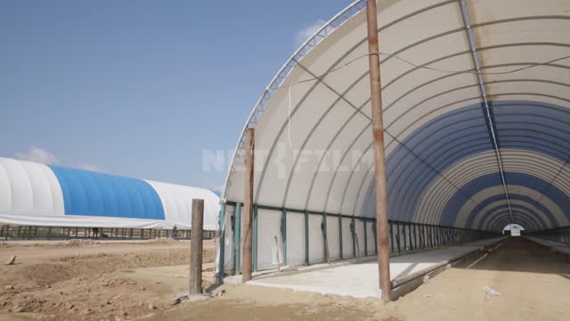 Hangar frames under blue and white awnings Ural, agriculture, construction, construction site,...