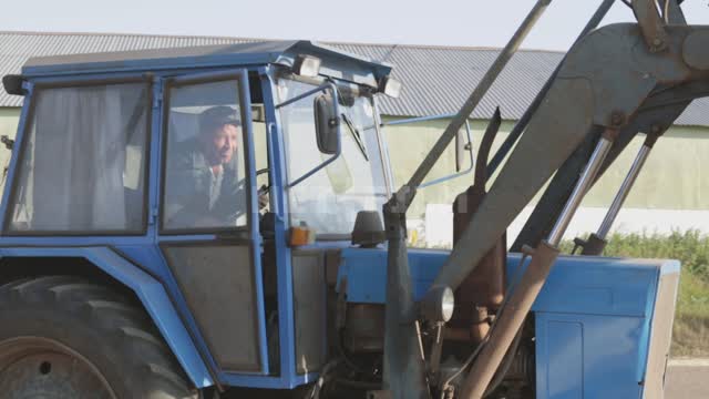 Зернохранилище, трактор подгребает зерно, собирает его в кучу Урал, зернохранилище, зерноток,...
