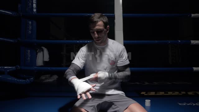 Boxer preparing for the sparring and pulls a bandage on his hand. Boxing.
Boxers.
The...
