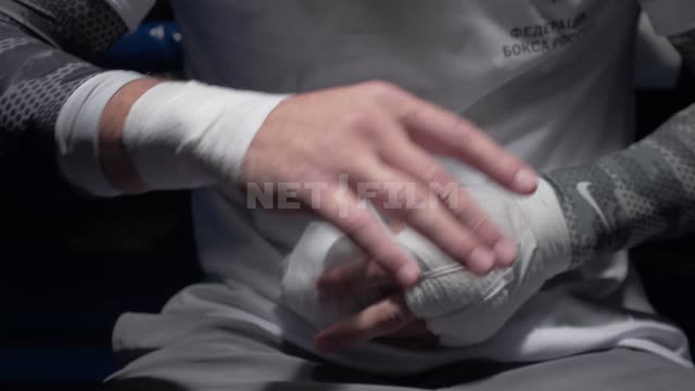 Poker puts a bandage on the hands before a fight. Boxing
Boxer
Headband
Hands
Fists
The ring