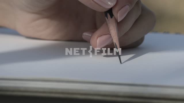 The man draws a line with pencil on paper Paper, line sheets, pencil, hand, close-up