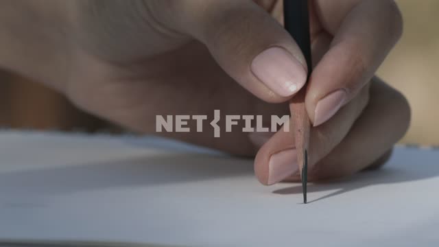 The man draws a line with pencil on paper Paper, line, pencil, hand, close-up