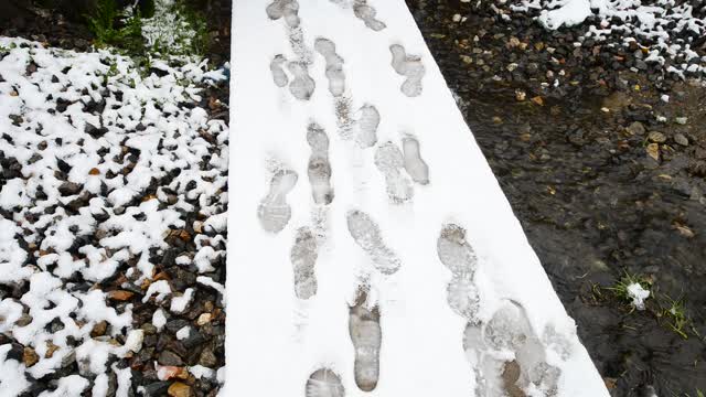 Footprints on a snowy path. Traces, footpath, snow, thawed patches, Creek, stones, early spring,...