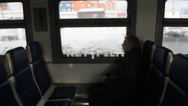 Мужчина в вагоне движущейся электрички Электропоезд, зима, город, человек, сидения, вагон, движение