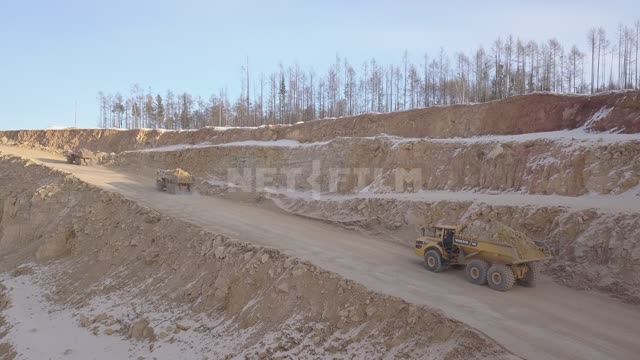 Gold mining, dump trucks take ore out of the quarry Gold mine, quarry, gold mining, minerals,...