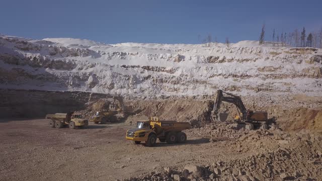 Gold mining, excavators pour ore into trucks Gold mine, quarry, gold mining, minerals, mining,...